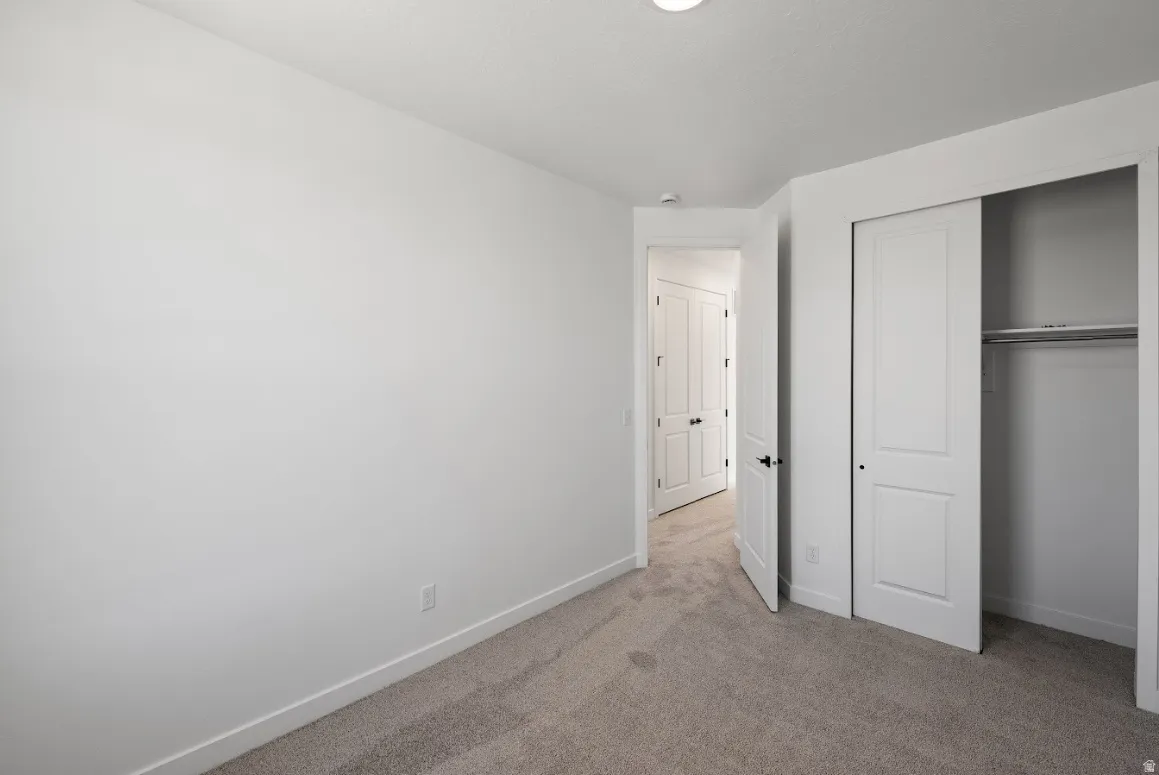 Unfurnished bedroom with carpet and a closet