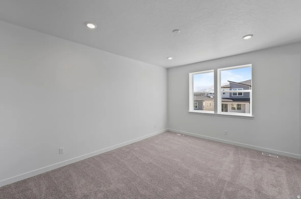 Carpeted spare room with recessed lighting