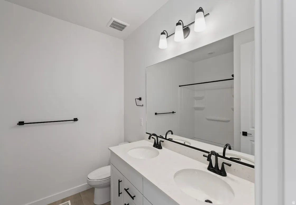 Bathroom with double vanity and light wood-style flooring