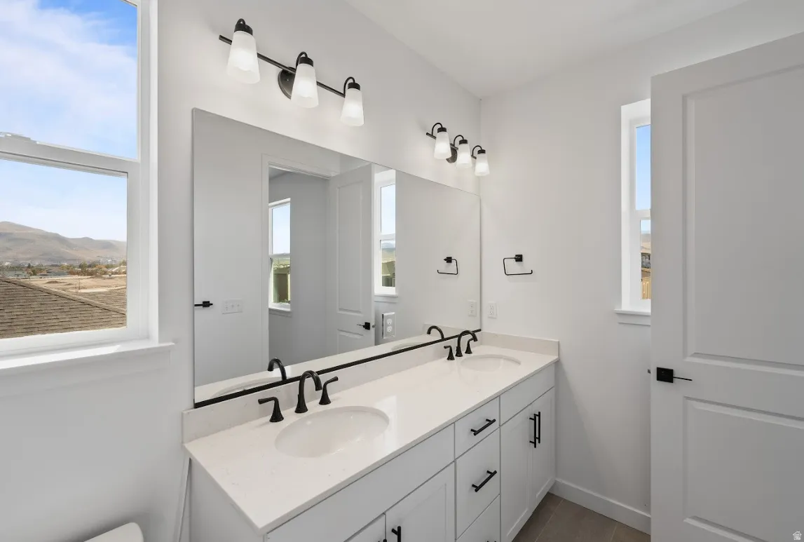 Bathroom with double vanity and healthy amount of natural light