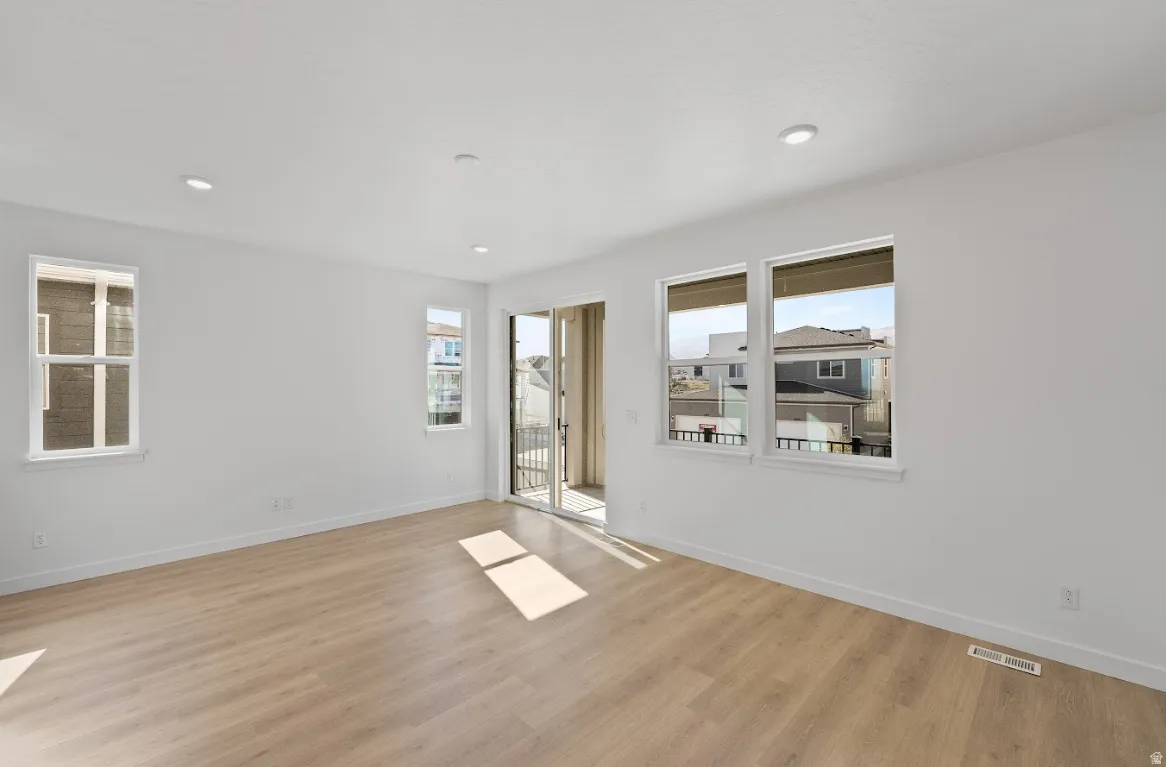 Empty room featuring light wood-type flooring and recessed lighting