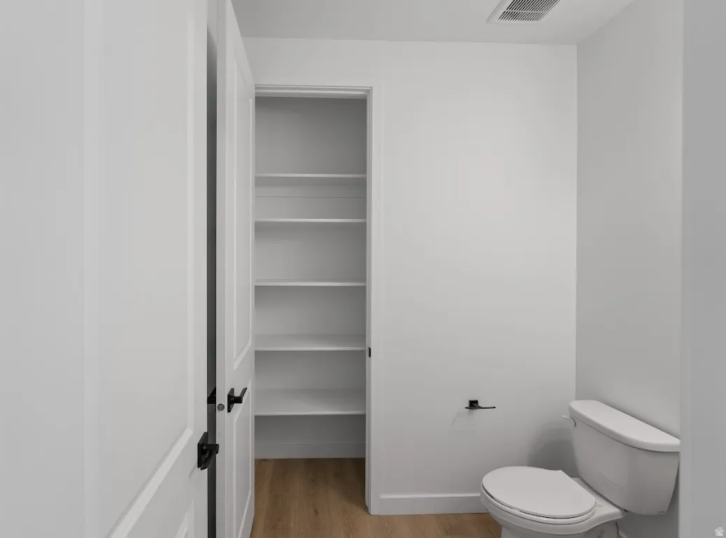 Bathroom with light wood-style flooring and toilet