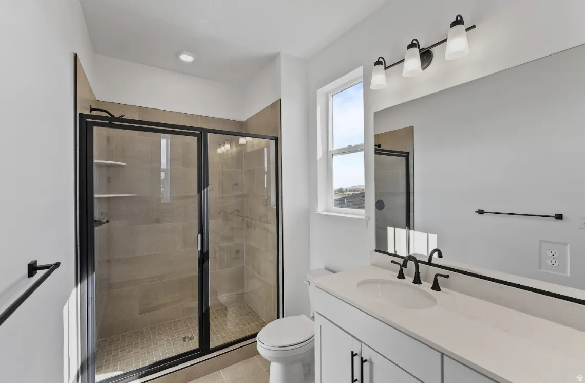 Full bathroom with a stall shower, vanity, and light tile patterned floors