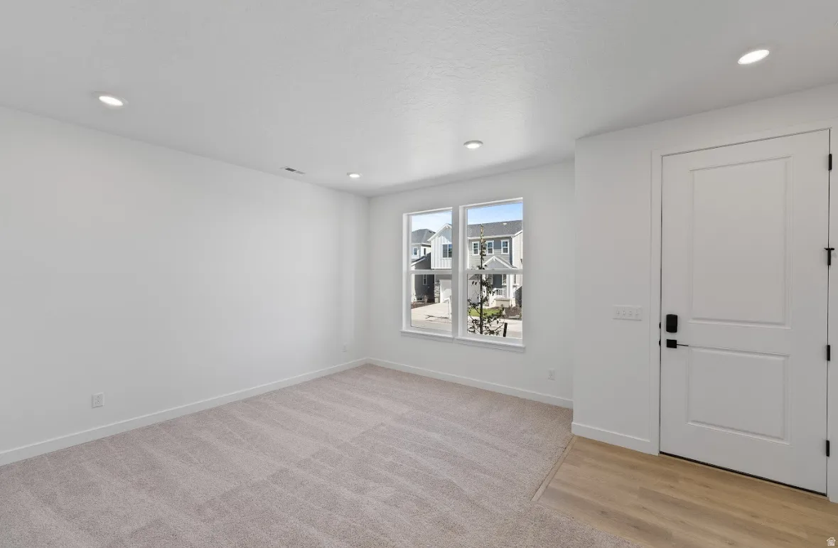 Foyer entrance featuring light colored carpet and recessed lighting