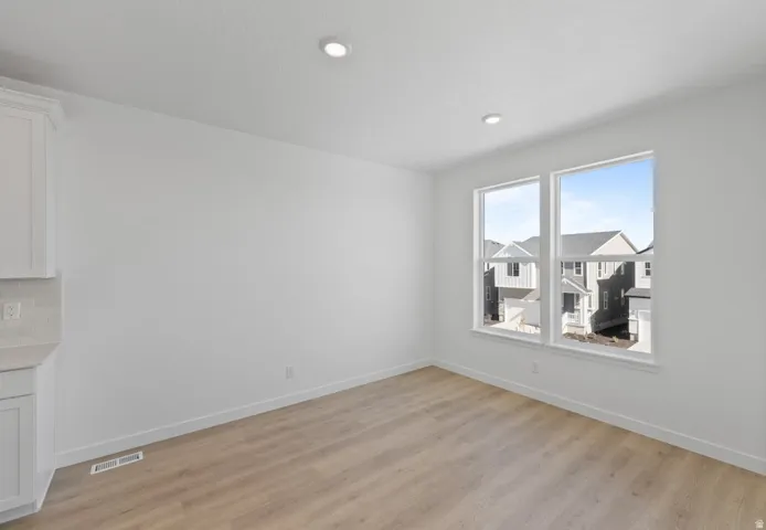 Empty room with light wood-type flooring and recessed lighting