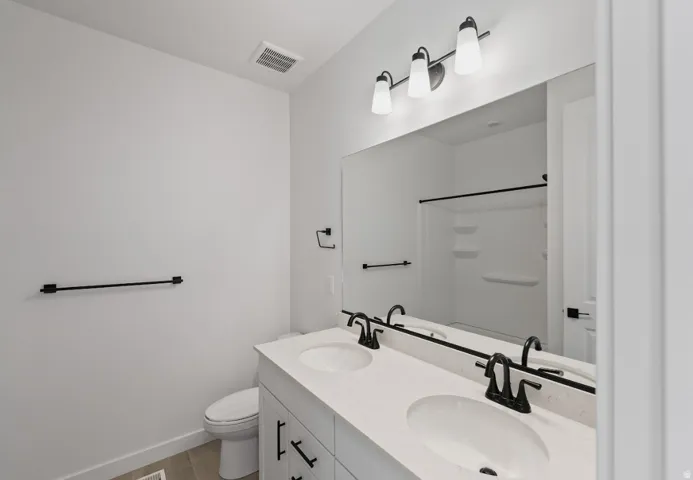 Bathroom with double vanity and light wood-style flooring