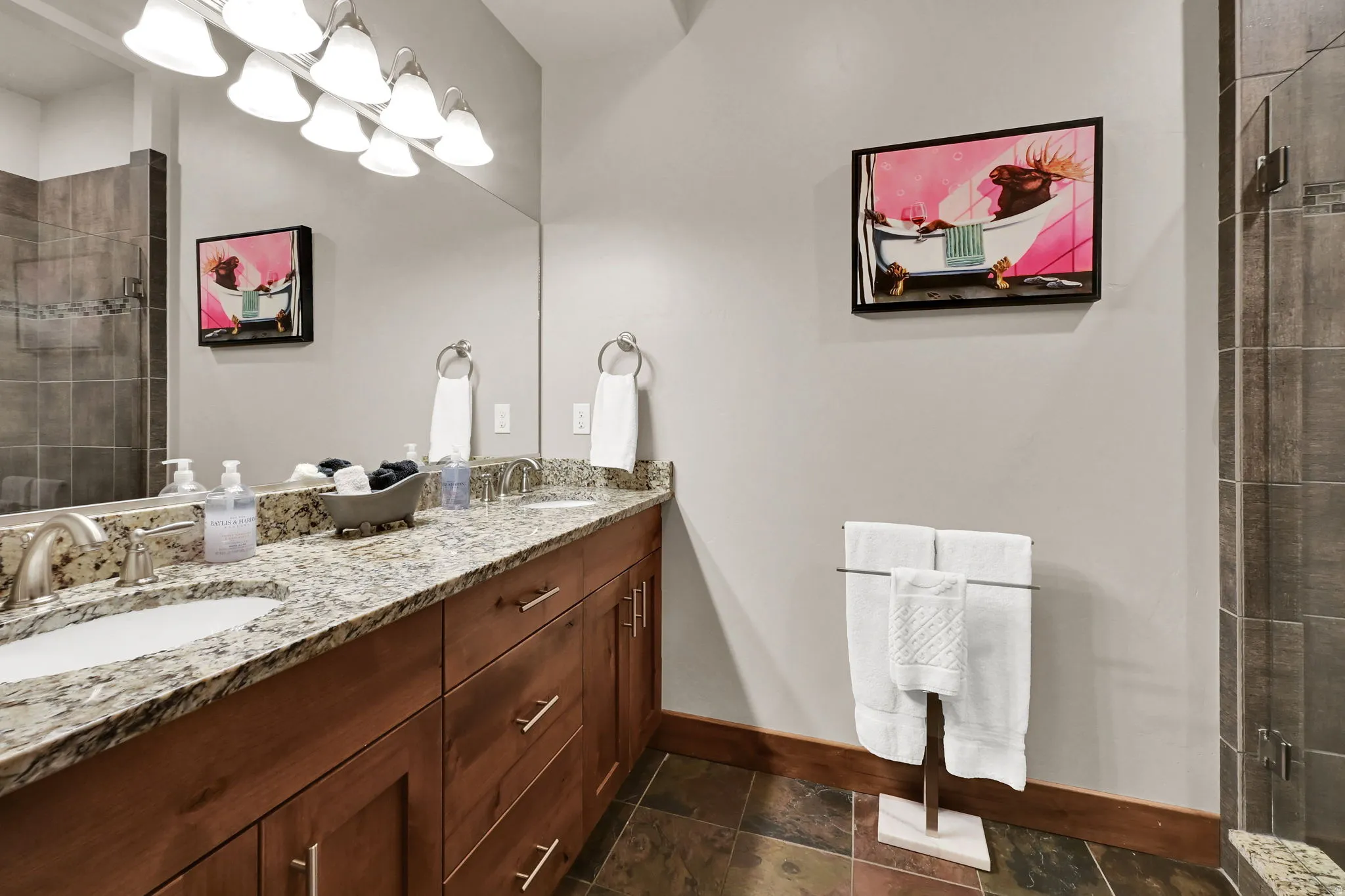 Bathroom featuring a stall shower and double vanity