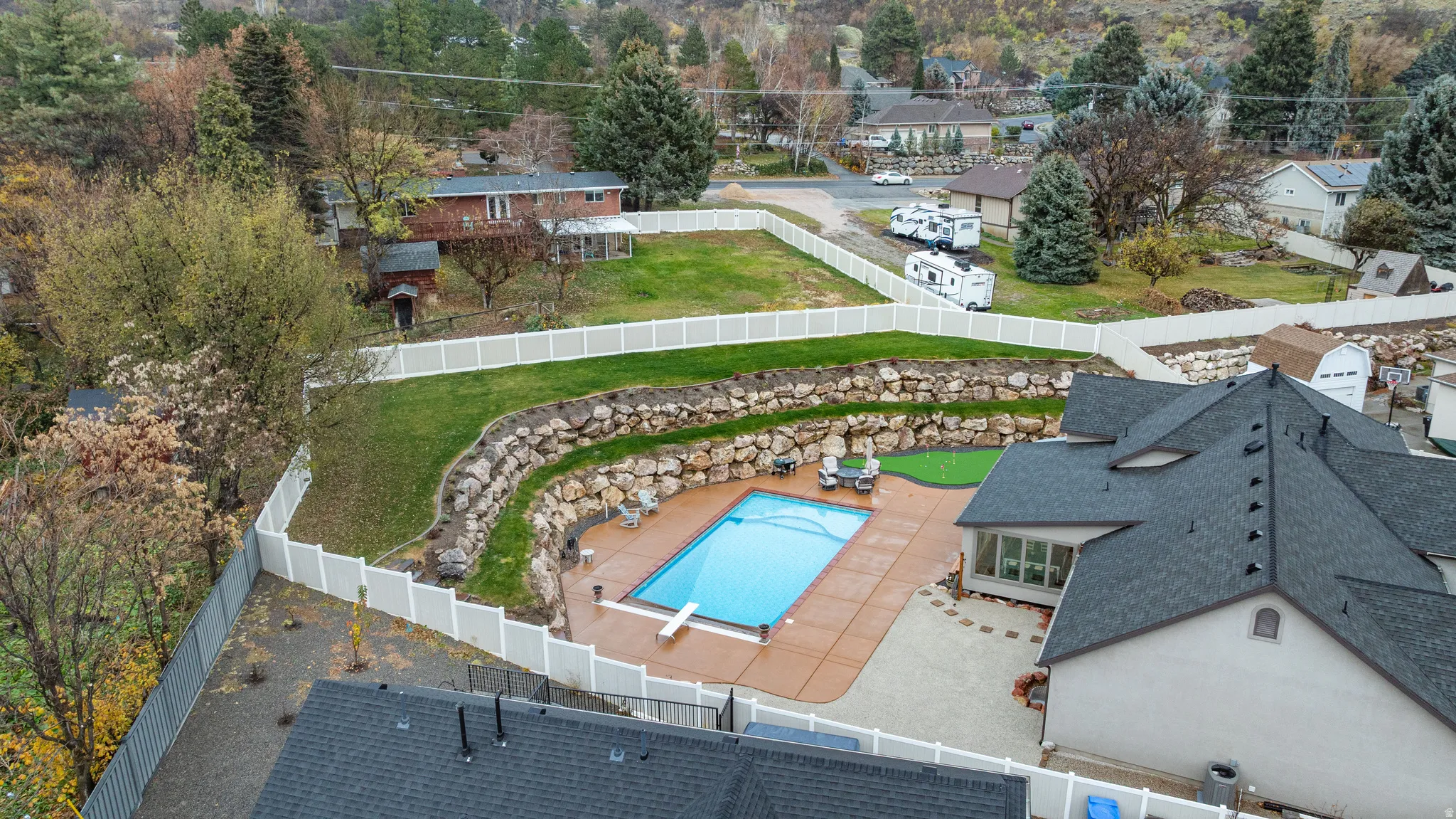 Drone / aerial view of a pool and a tree filled landscape