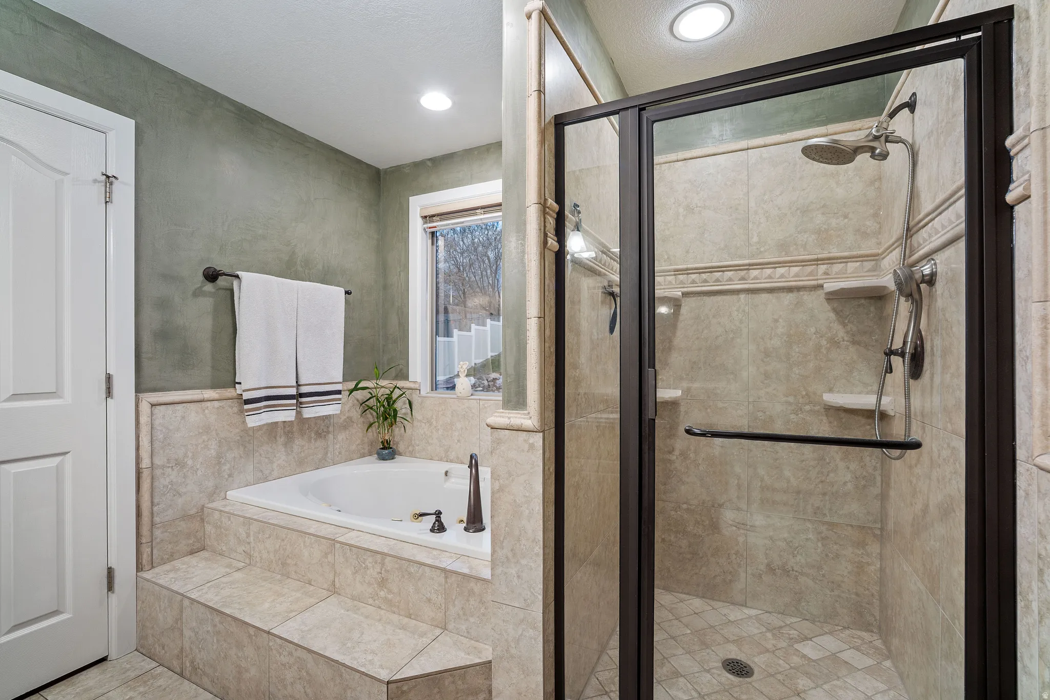 Bathroom with a garden tub, a stall shower, and recessed lighting