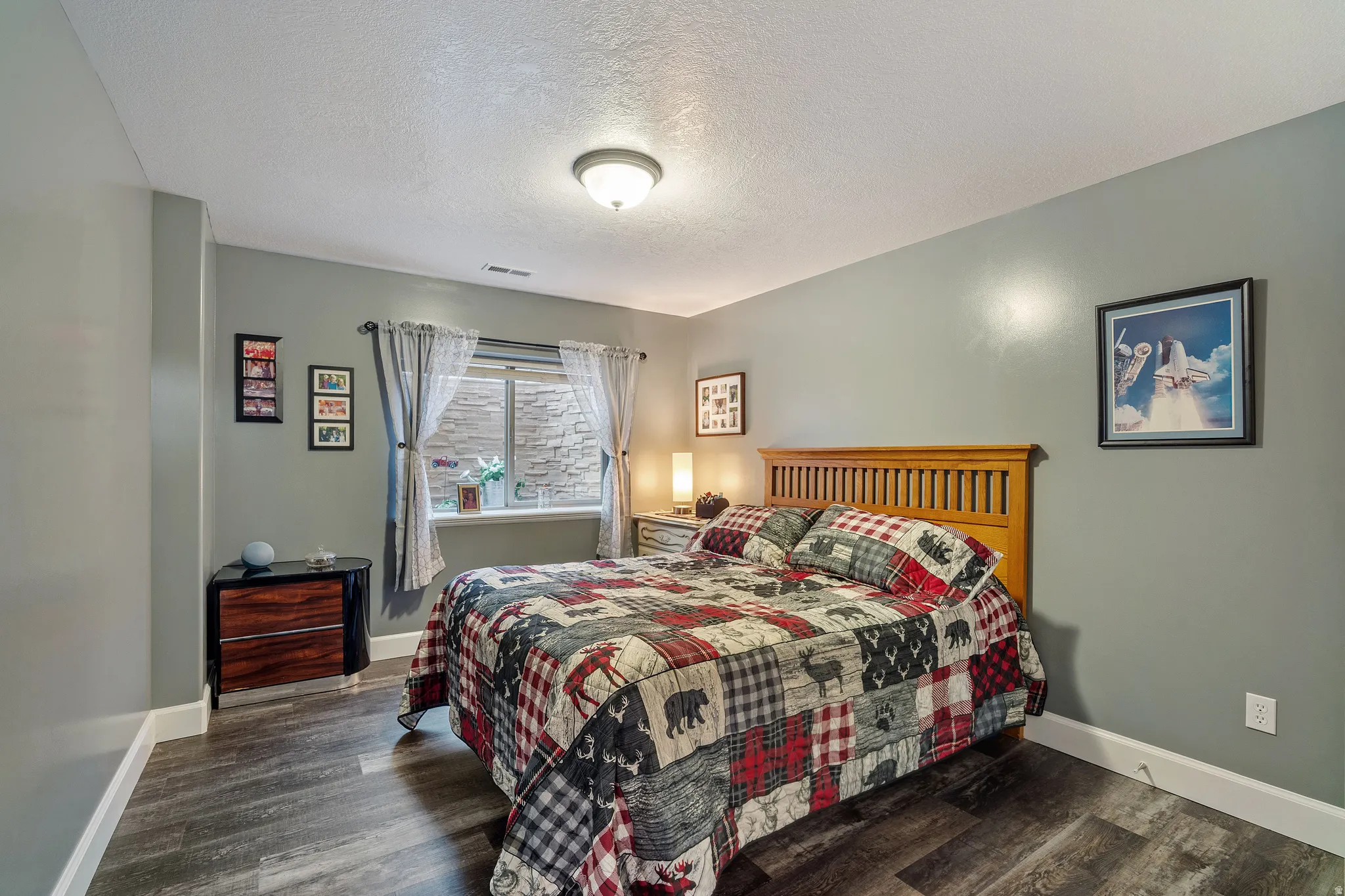 Bedroom featuring a textured ceiling and dark wood-type flooring