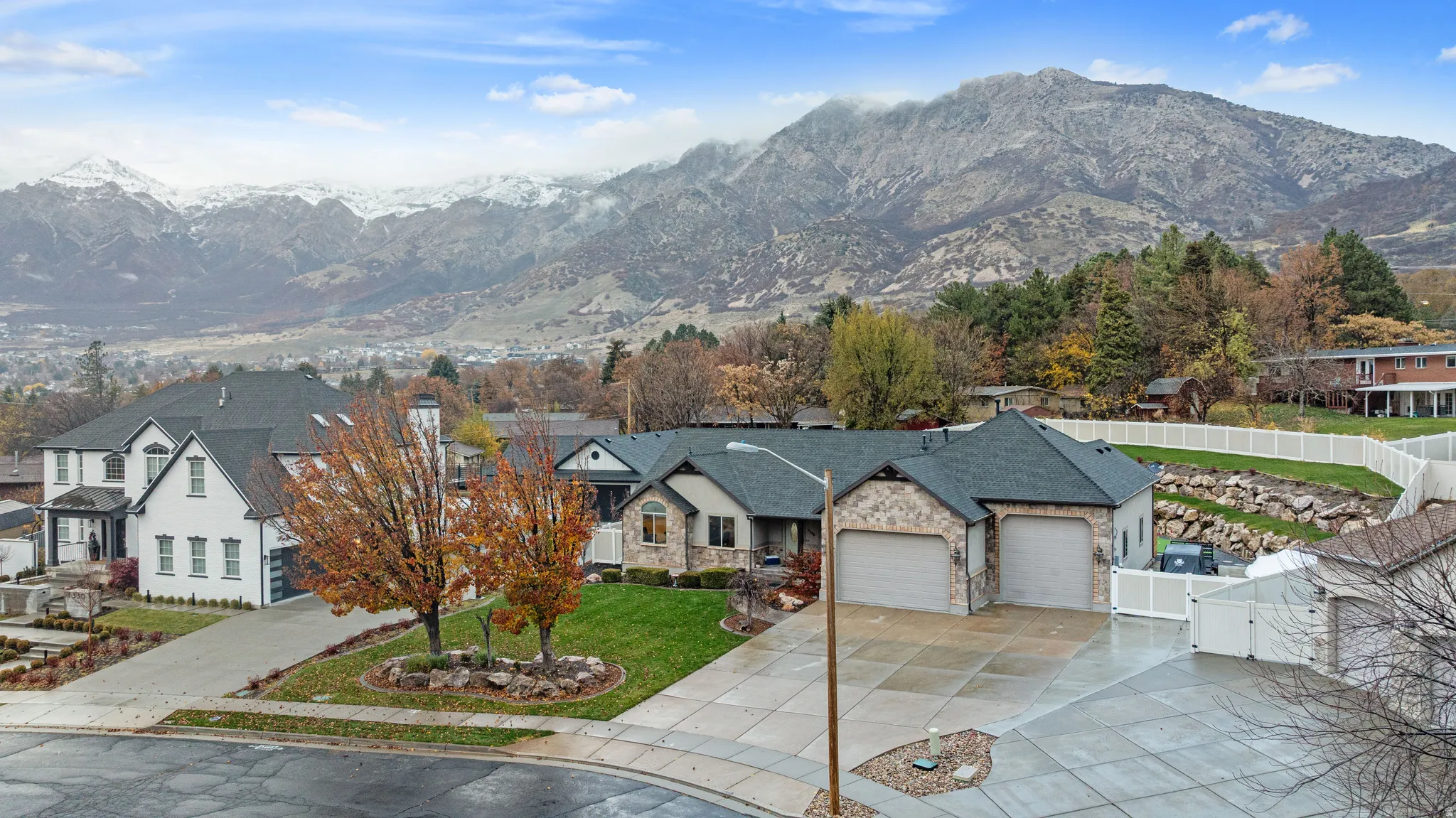 View of front facade with a gate, a garage, stone siding, and a mountain view