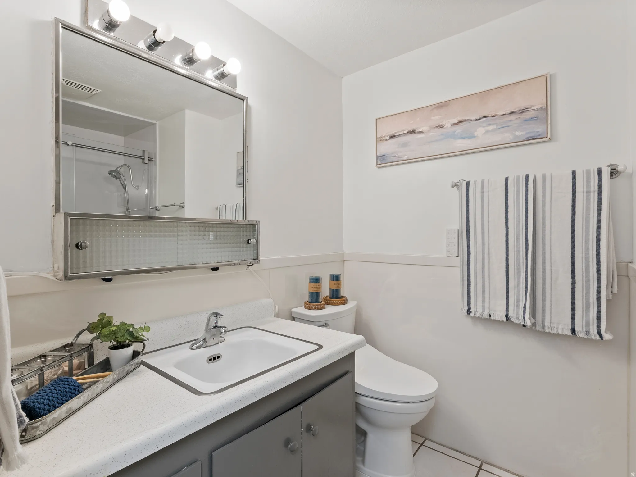 Bathroom with a shower with shower door, vanity, and light tile patterned floors