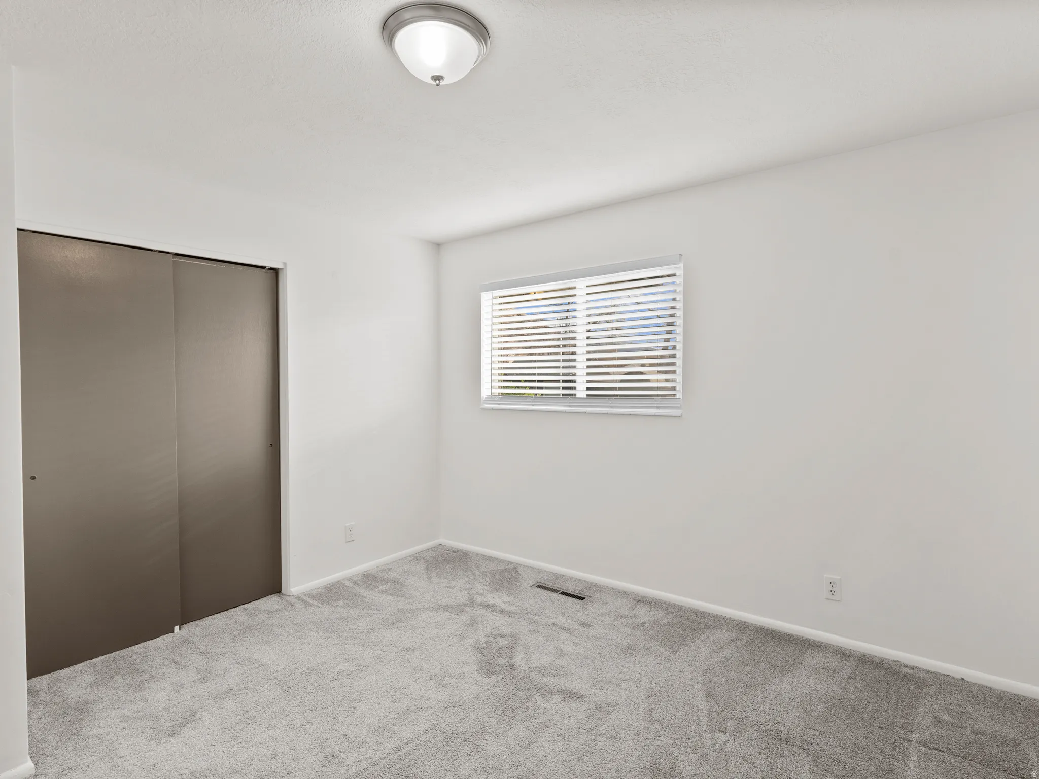 Unfurnished bedroom with a closet and carpet