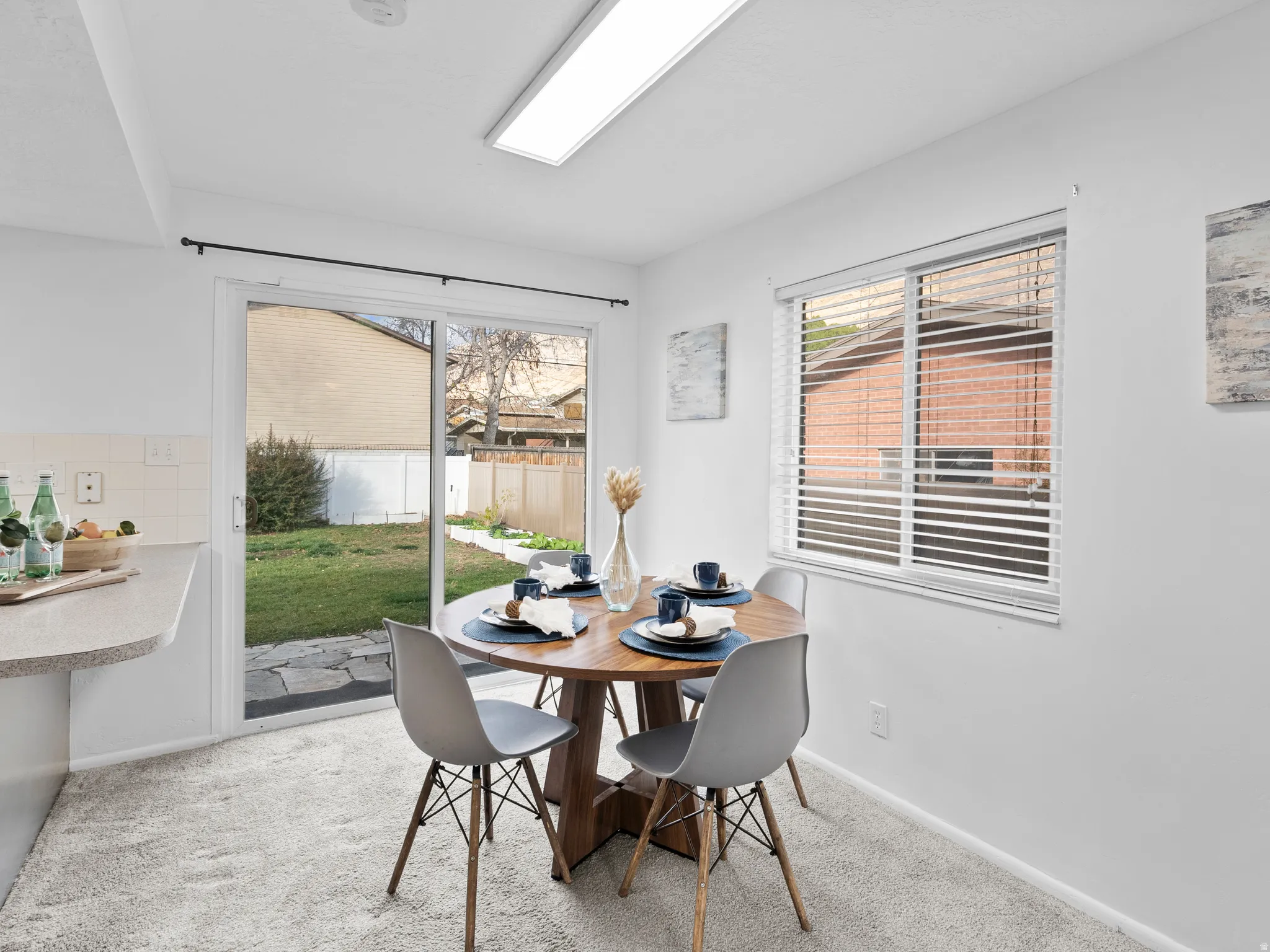 Dining space with light colored carpet and baseboards