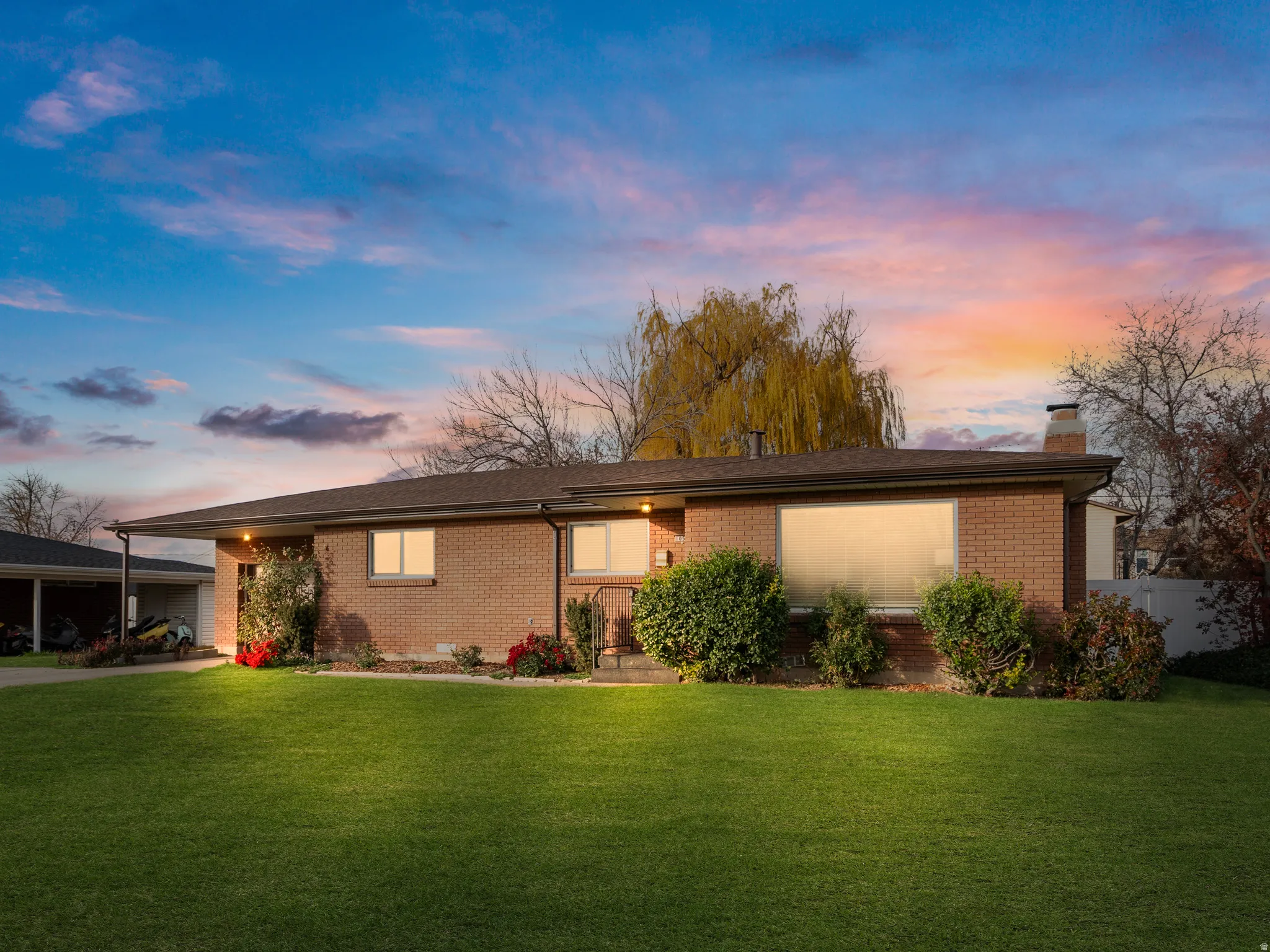 View of front of property featuring brick siding, a front yard, and a chimney