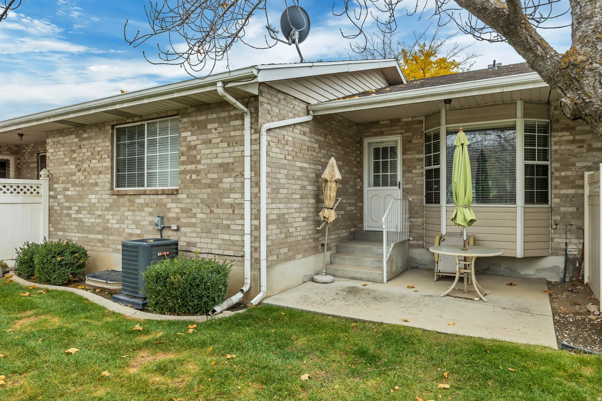 Entrance to property featuring a lawn and brick siding