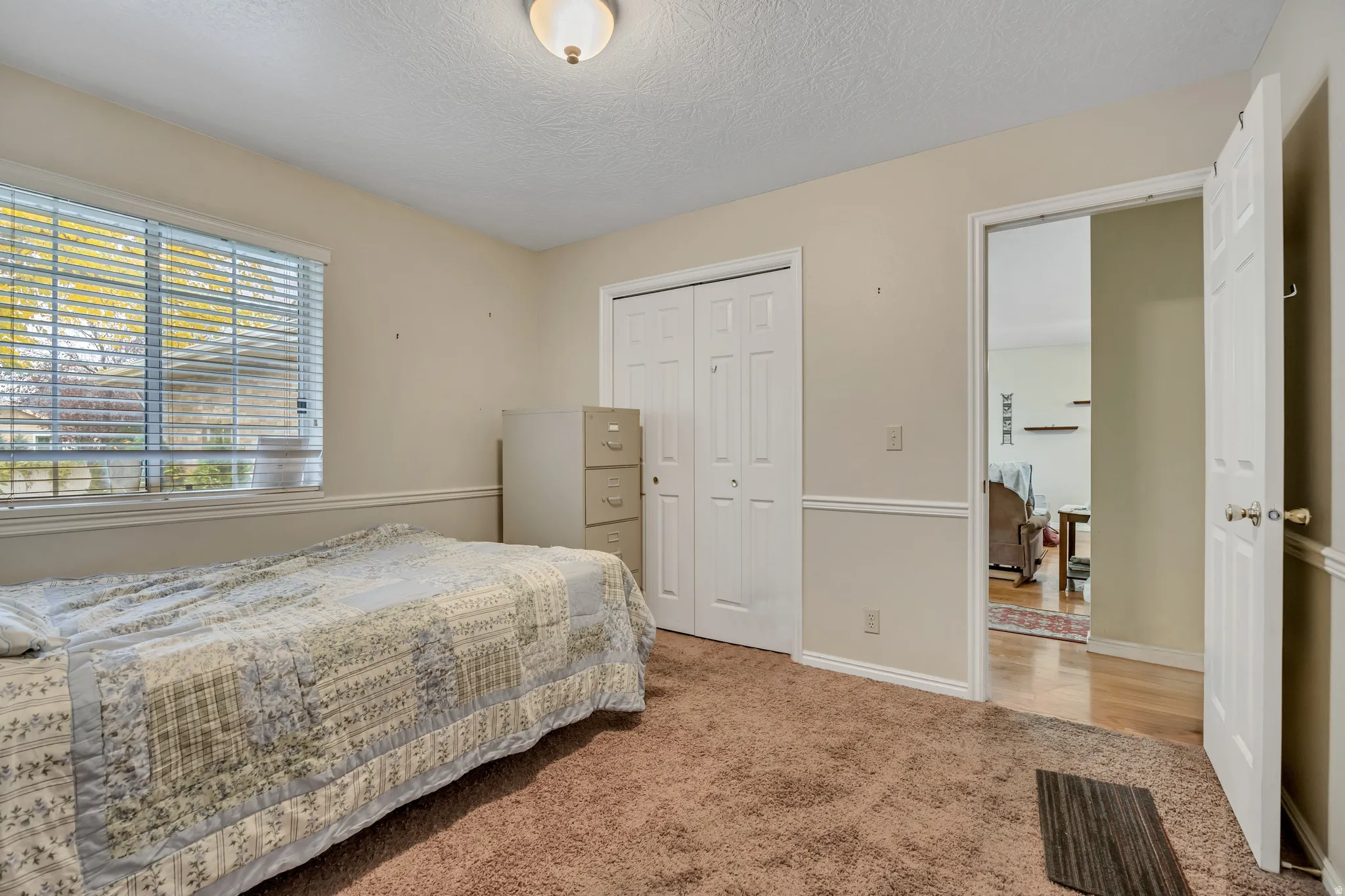 Bedroom with carpet, a closet, and a textured ceiling