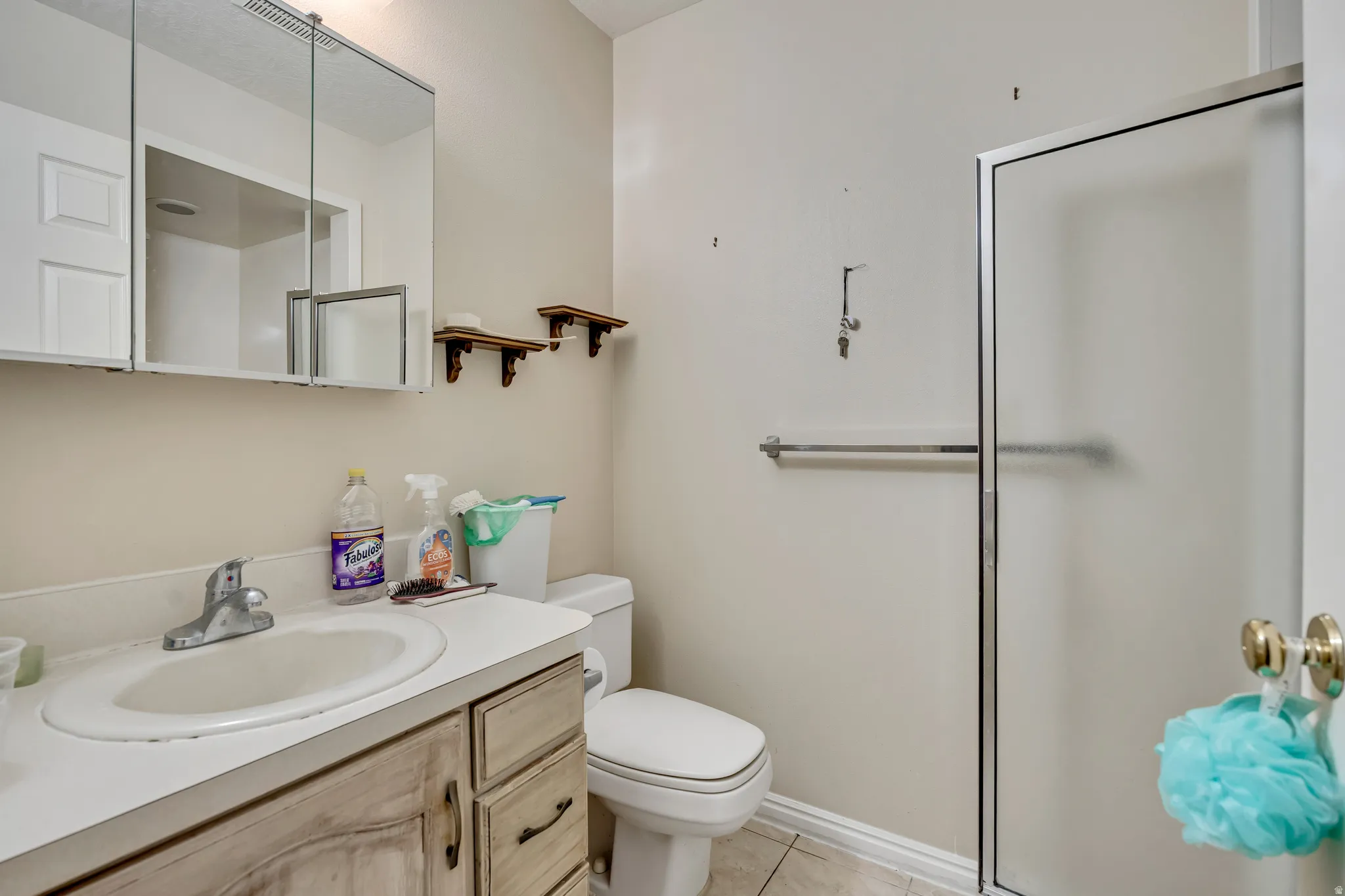 Bathroom with vanity, a stall shower, and light tile patterned flooring