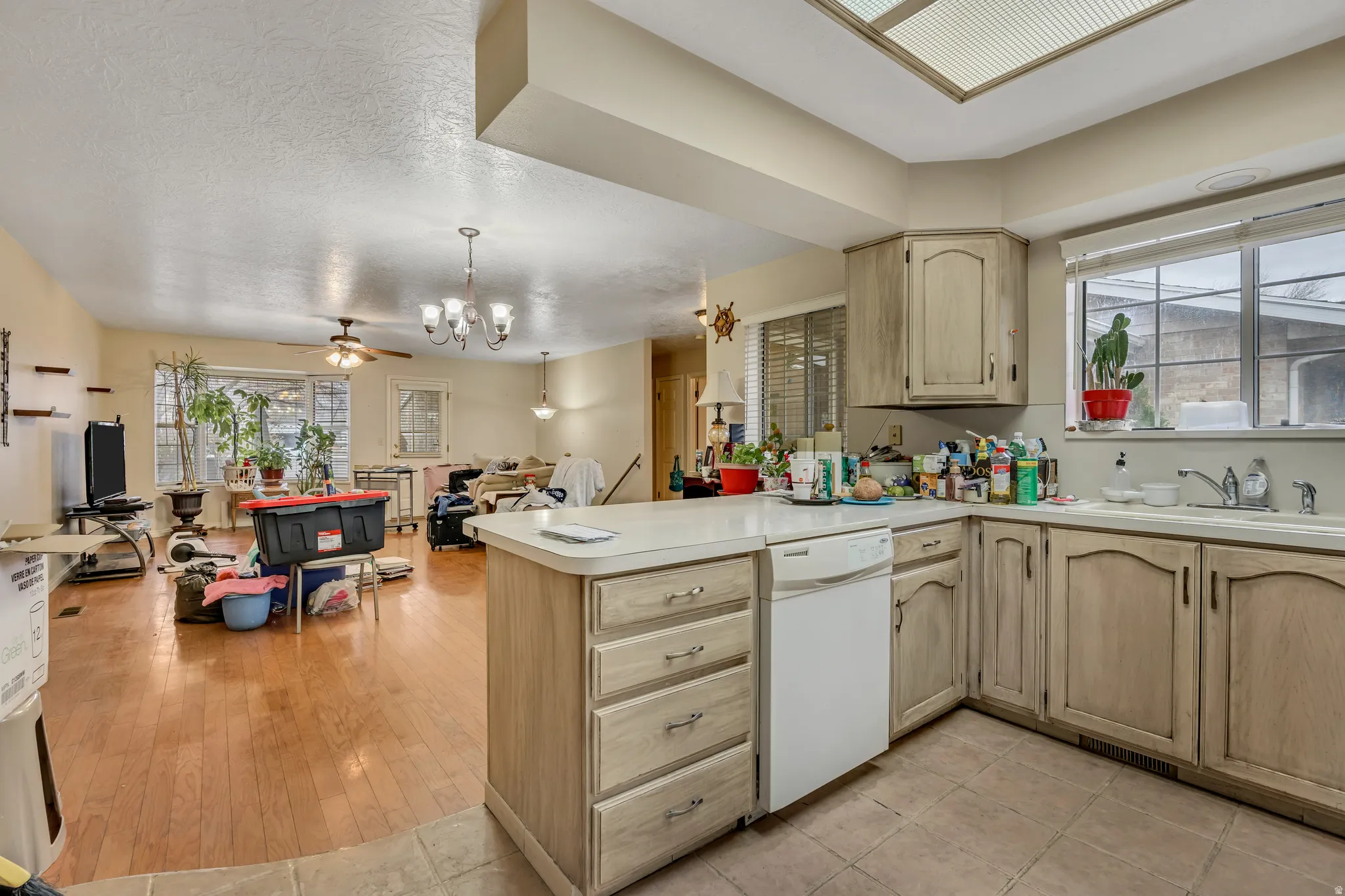 Kitchen featuring light brown cabinets, light countertops, open floor plan, and a textured ceiling