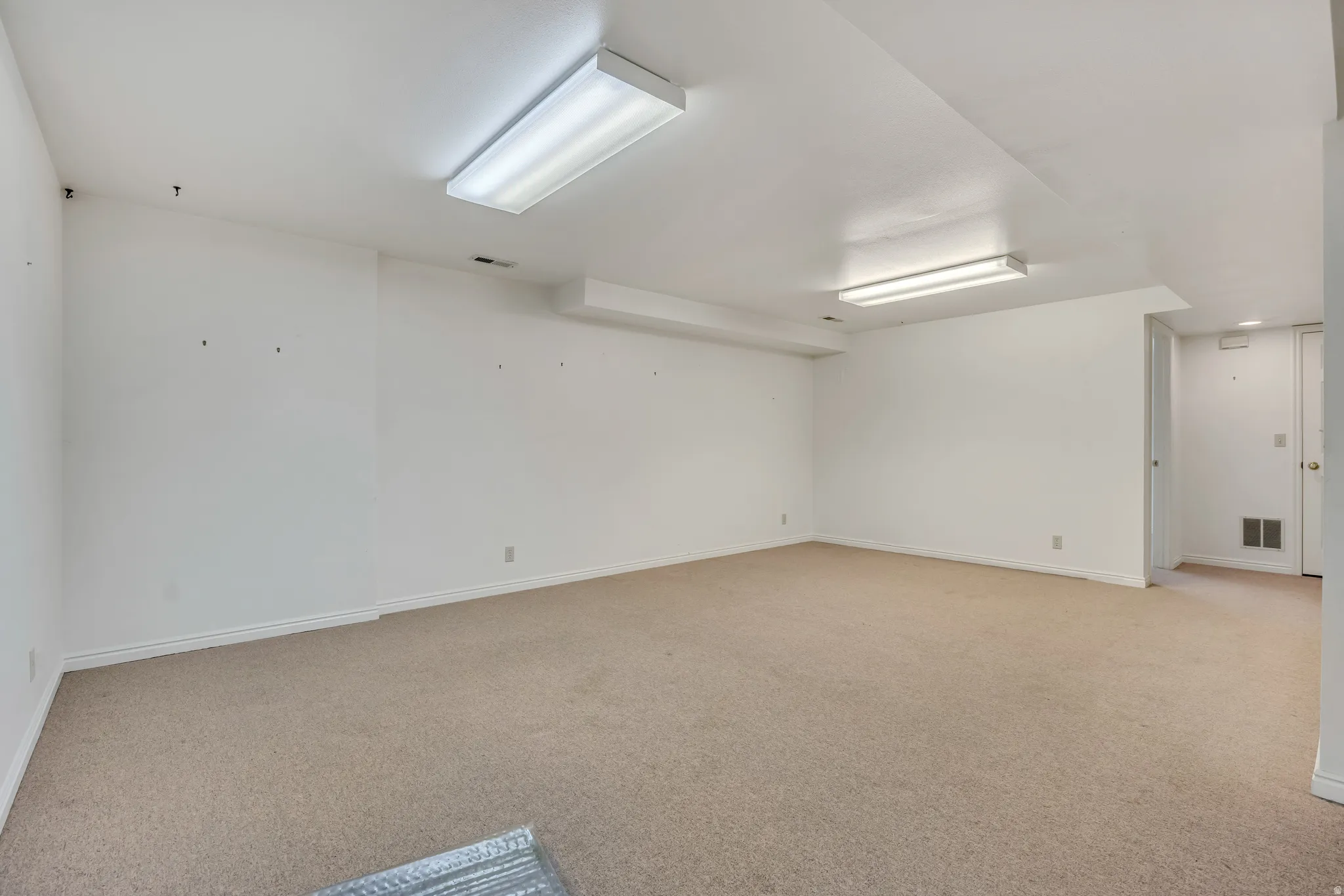 Spare room with light carpet and baseboards