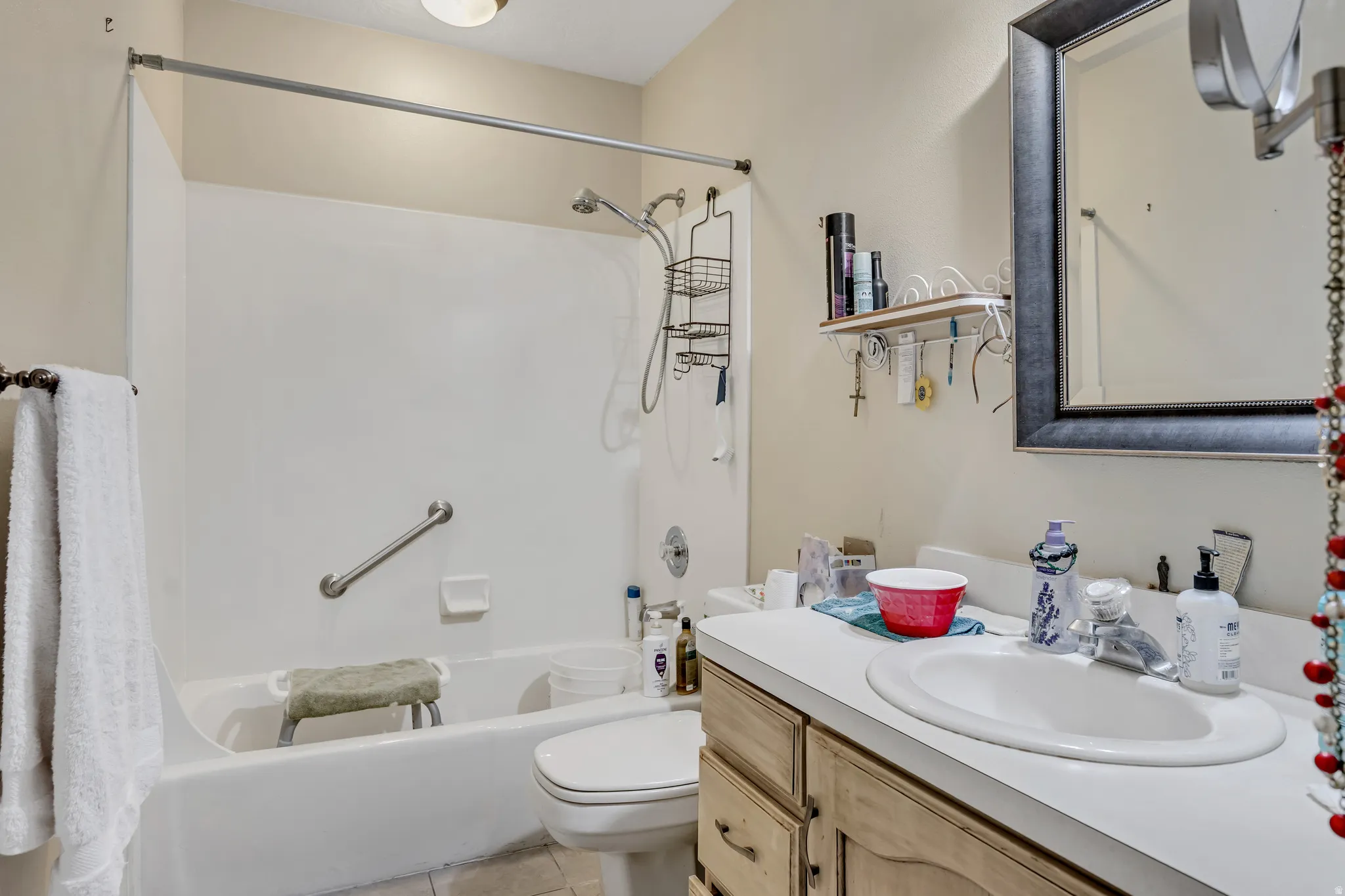 Full bath featuring shower / bath combo with shower curtain, vanity, and light tile patterned floors