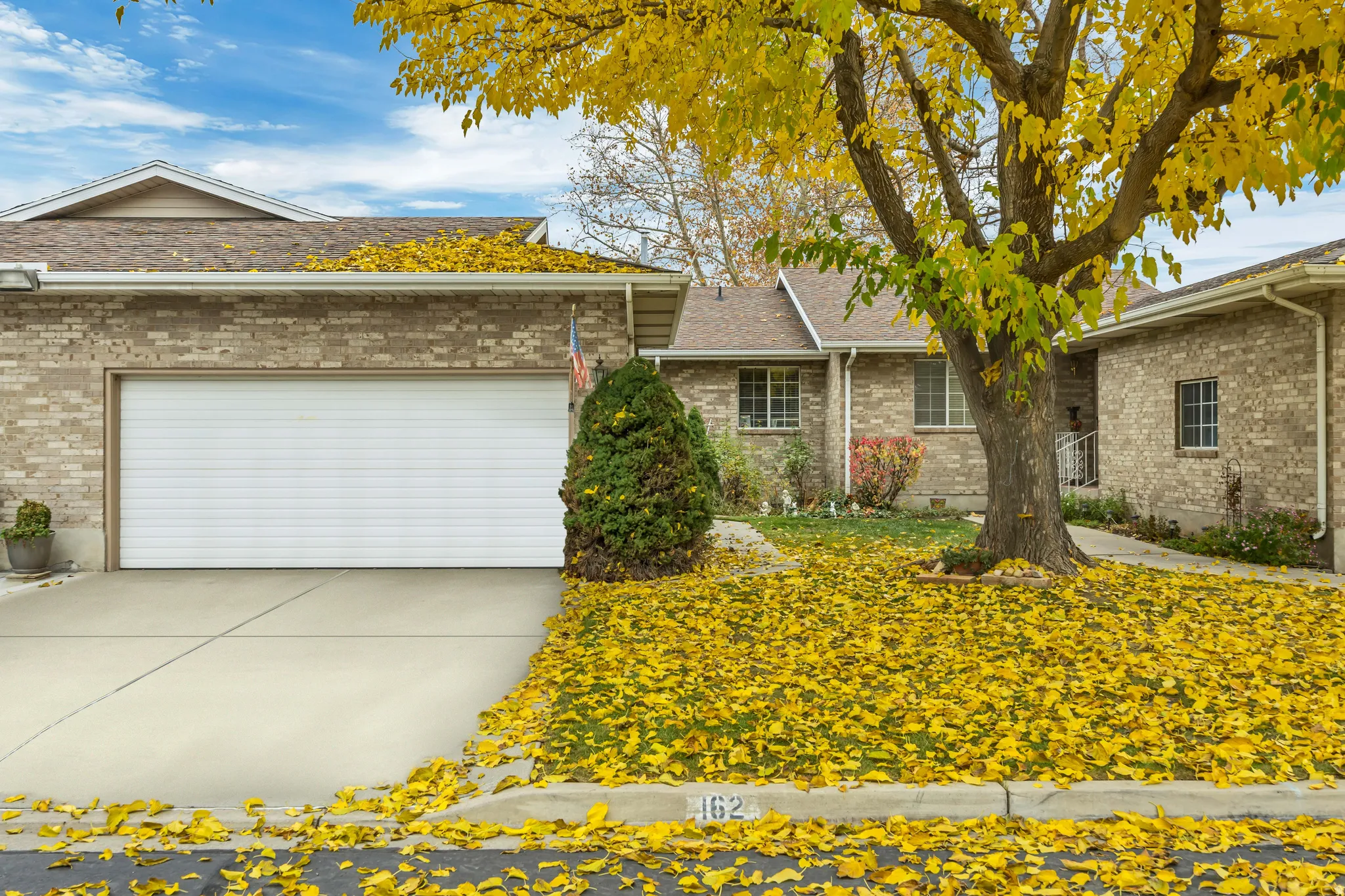 Ranch-style house with brick siding, concrete driveway, an attached garage, and roof with shingles
