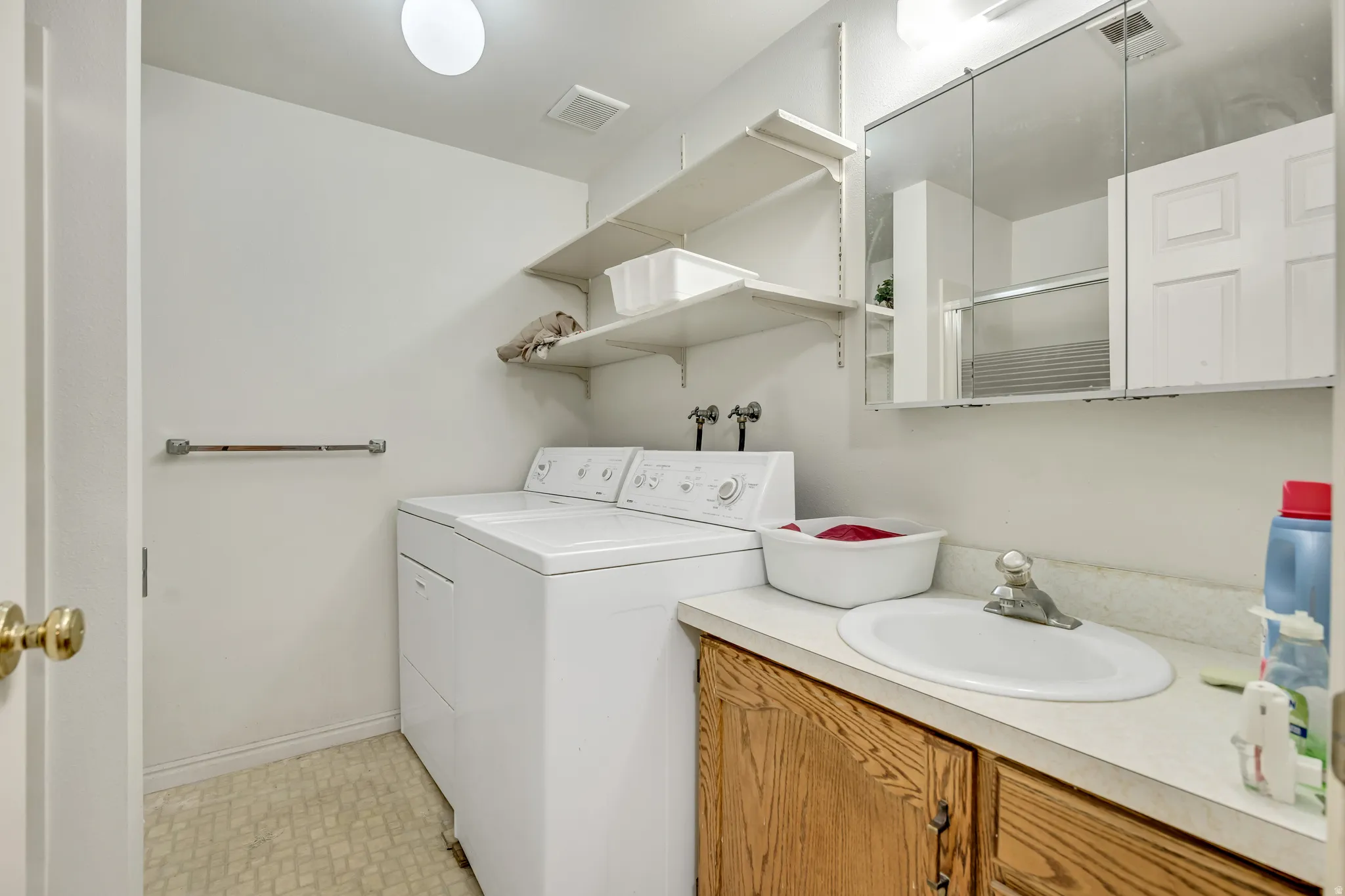 Laundry room with washing machine and dryer and light flooring