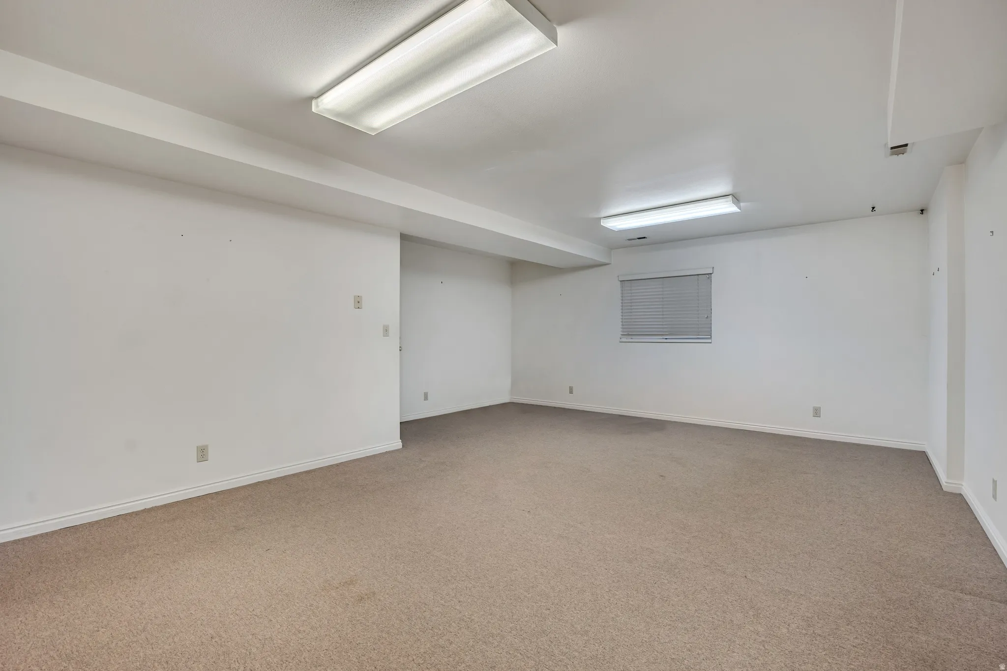 Unfurnished room featuring light colored carpet and baseboards