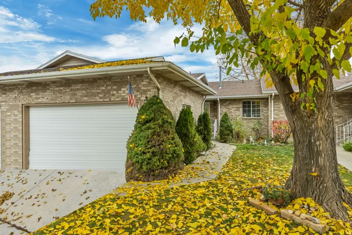 View of property exterior featuring a lawn, brick siding, and an attached garage