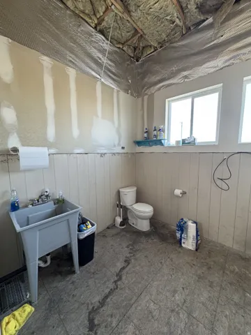 Bathroom with toilet and wood walls
