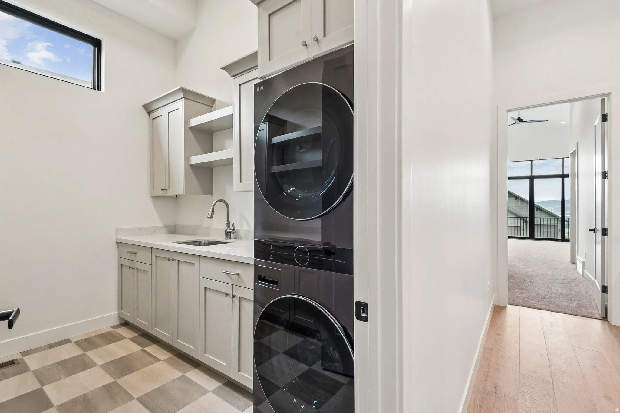 Laundry #2 with stacked washer and dryer, laundry sink, storage and opposite side pantry area.