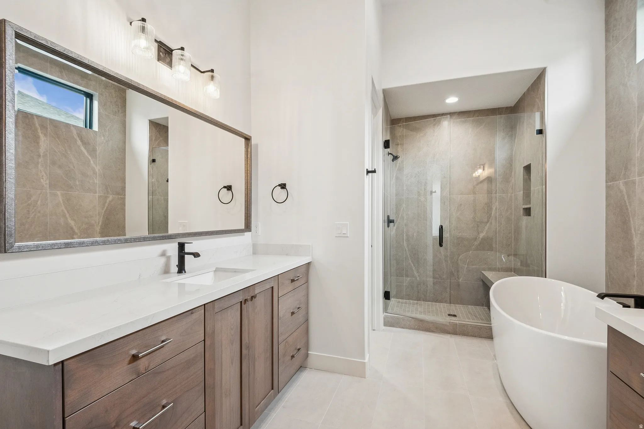Primary Bathroom (#6) featuring vanity, a soaking tub, Euro shower, and light patterned tile floors