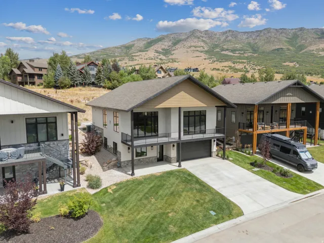 View of front of home featuring upper deck from family room/kitchen area and owner's suite