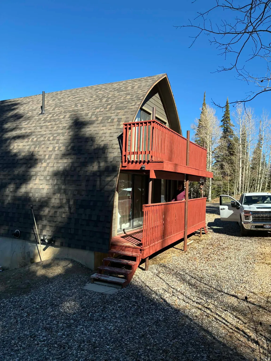 View of side of home featuring a deck and roof with shingles