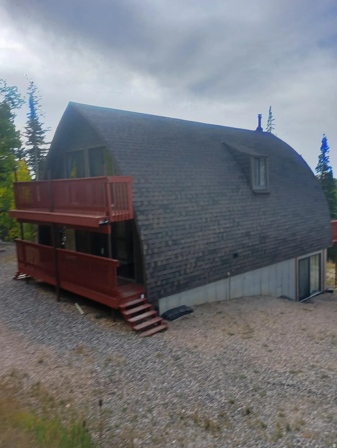 Back of house with a deck and roof with shingles