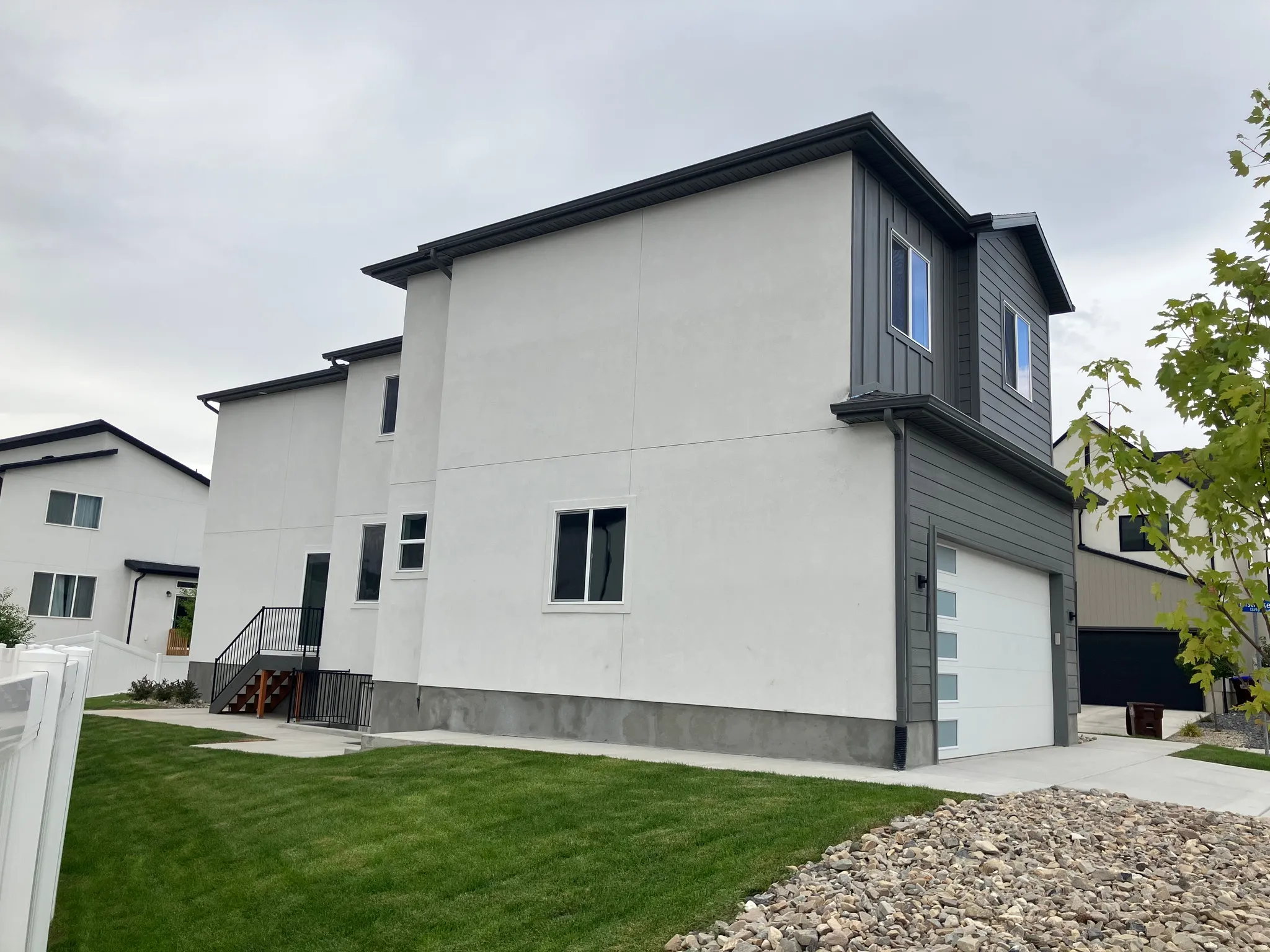 Contemporary exterior with white stucco and dark gray vertical siding accents