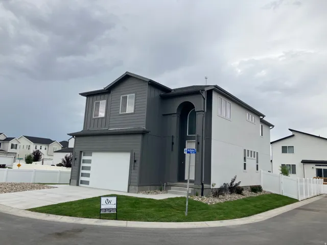 Contemporary two-story residence featuring a two-tone exterior with dark gray vertical siding and light gray stucco