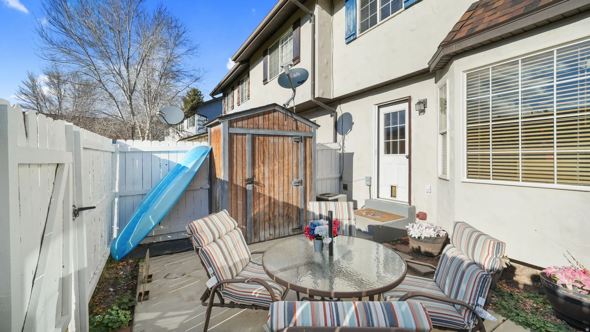 Fenced backyard with a storage unit, a patio area, and outdoor dining area