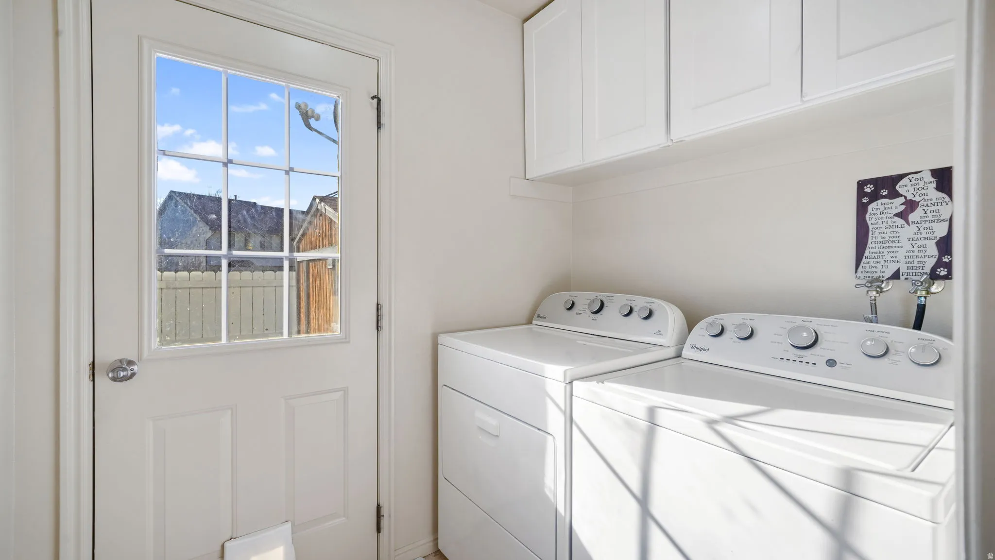 Washroom featuring separate washer and dryer and cabinet space