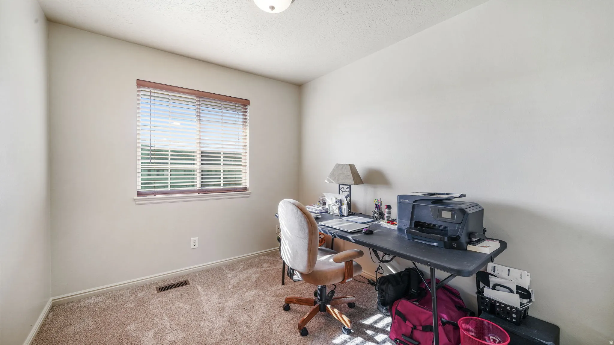 Home office featuring a textured ceiling and carpet floors