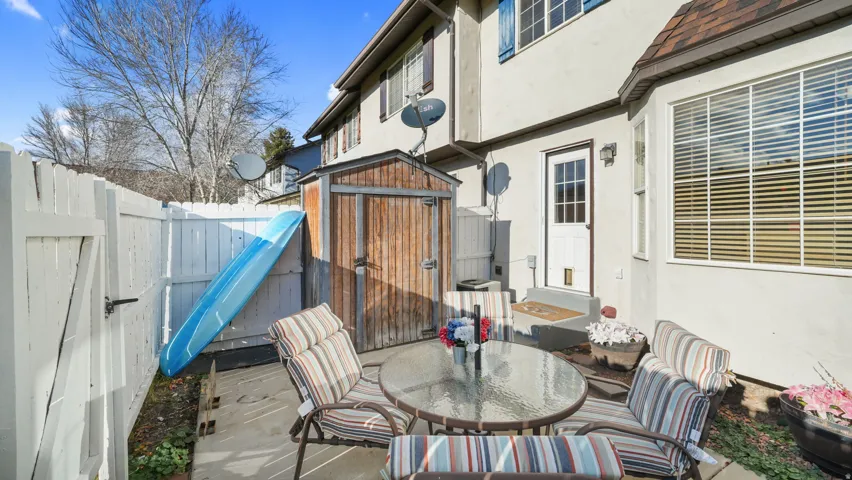 Fenced backyard with a storage unit, a patio area, and outdoor dining area