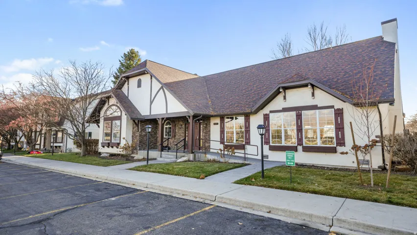 View of front facade featuring roof with shingles, uncovered parking, and a front lawn