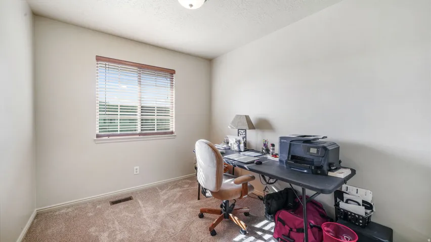 Home office featuring a textured ceiling and carpet floors