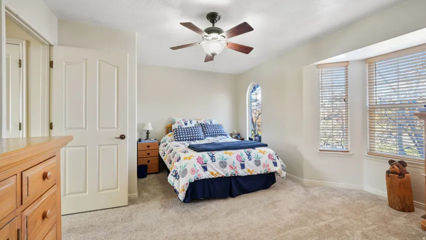 Bedroom featuring light carpet and ceiling fan