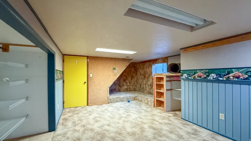Unfurnished bedroom with carpet and wood walls