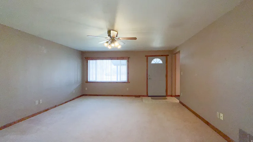 Entrance foyer with light carpet and ceiling fan