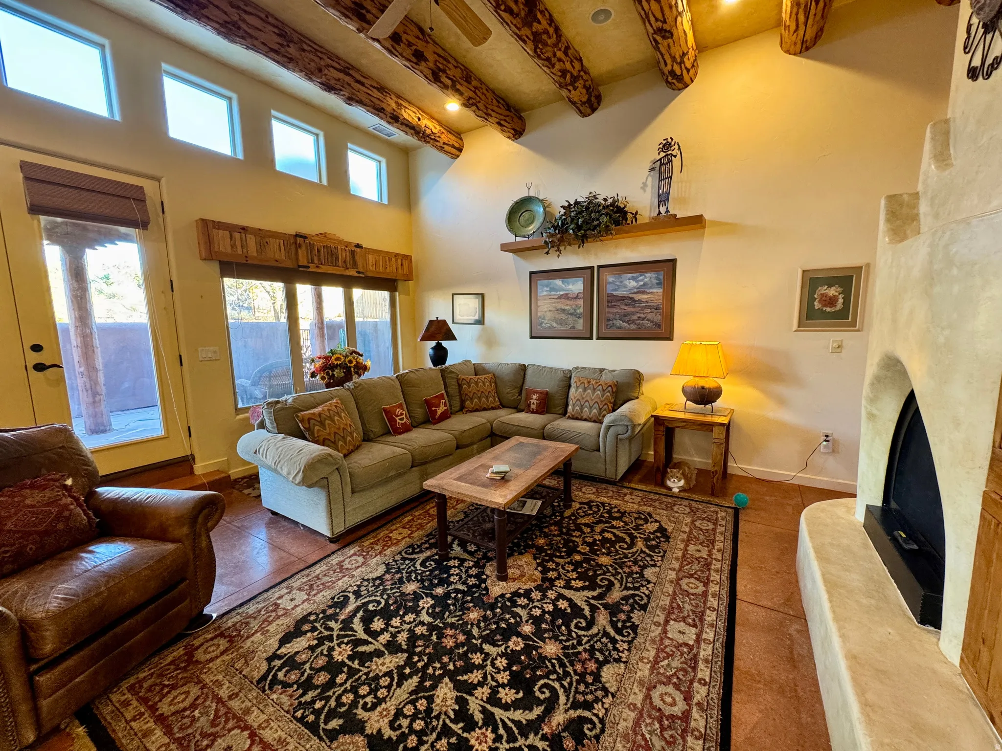 Tiled living room featuring a high end fireplace, a towering ceiling, and beam ceiling