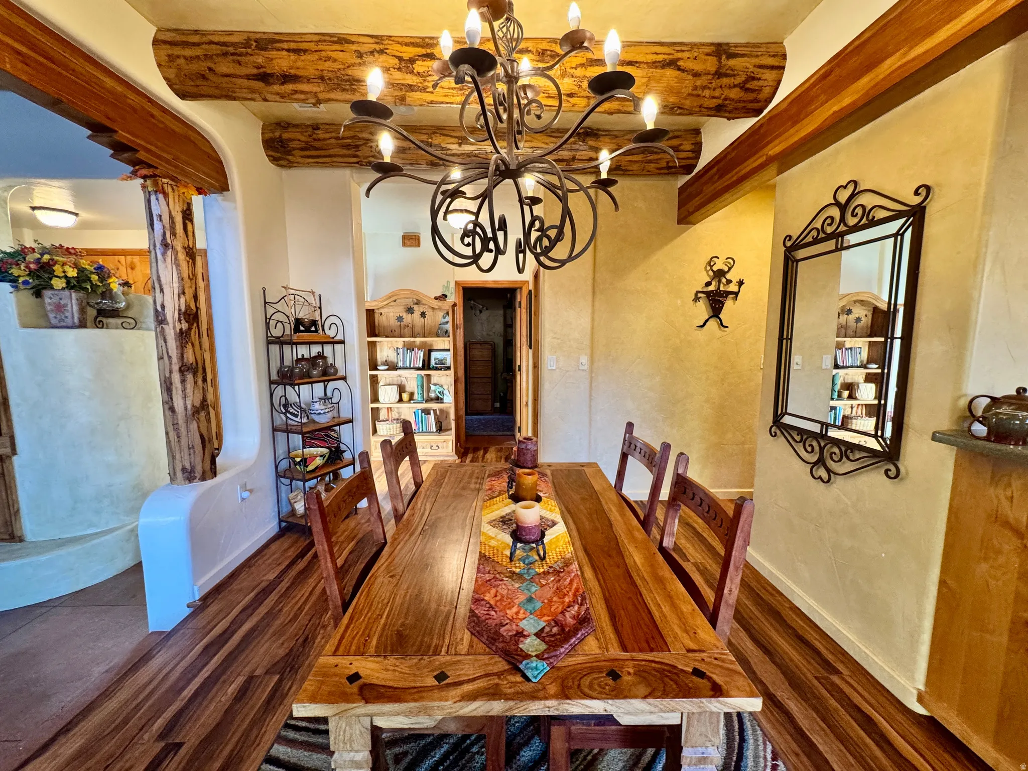 Dining area featuring beam ceiling, dark wood-style floors, and a chandelier