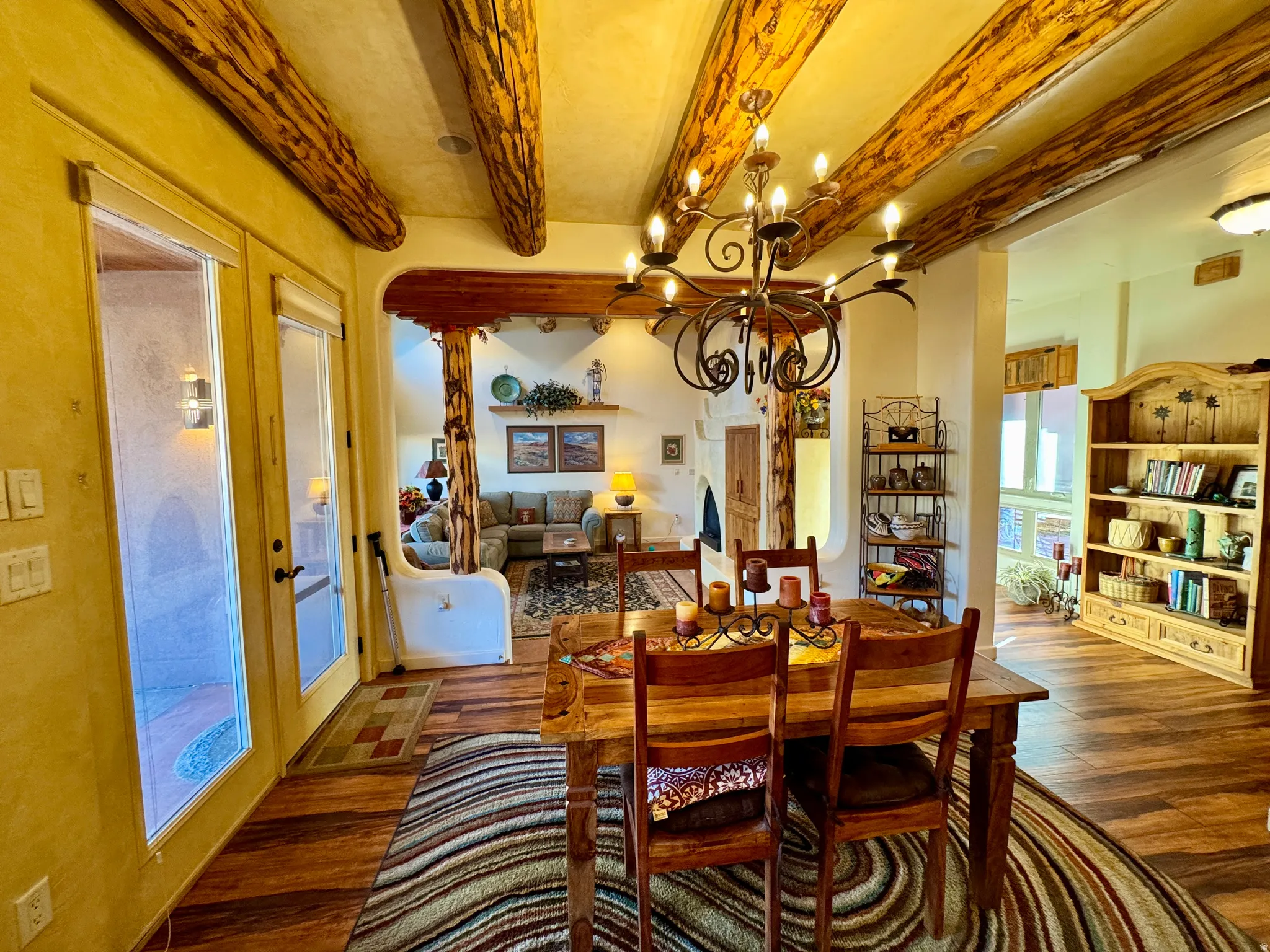 Dining area featuring beam ceiling, a chandelier, and wood finished floors