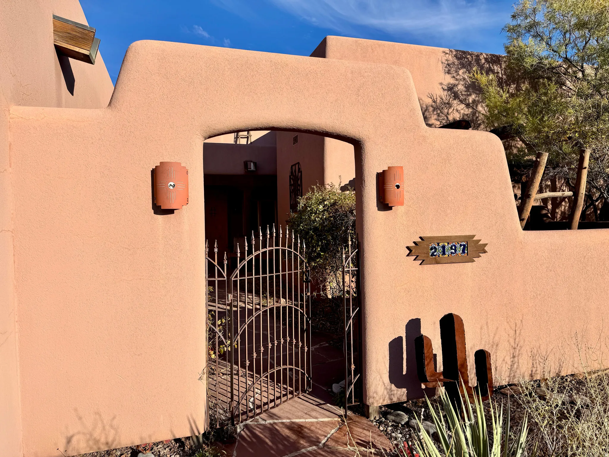View of exterior entry with a gate and stucco siding